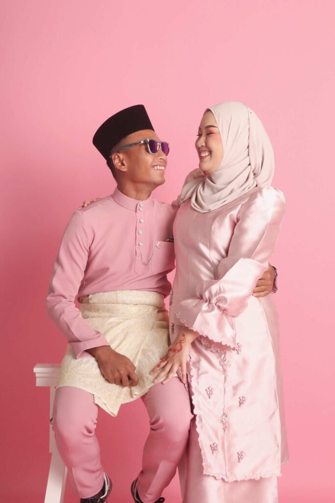 Lovely Malay couple photo wearing a traditional clothes with a pink background