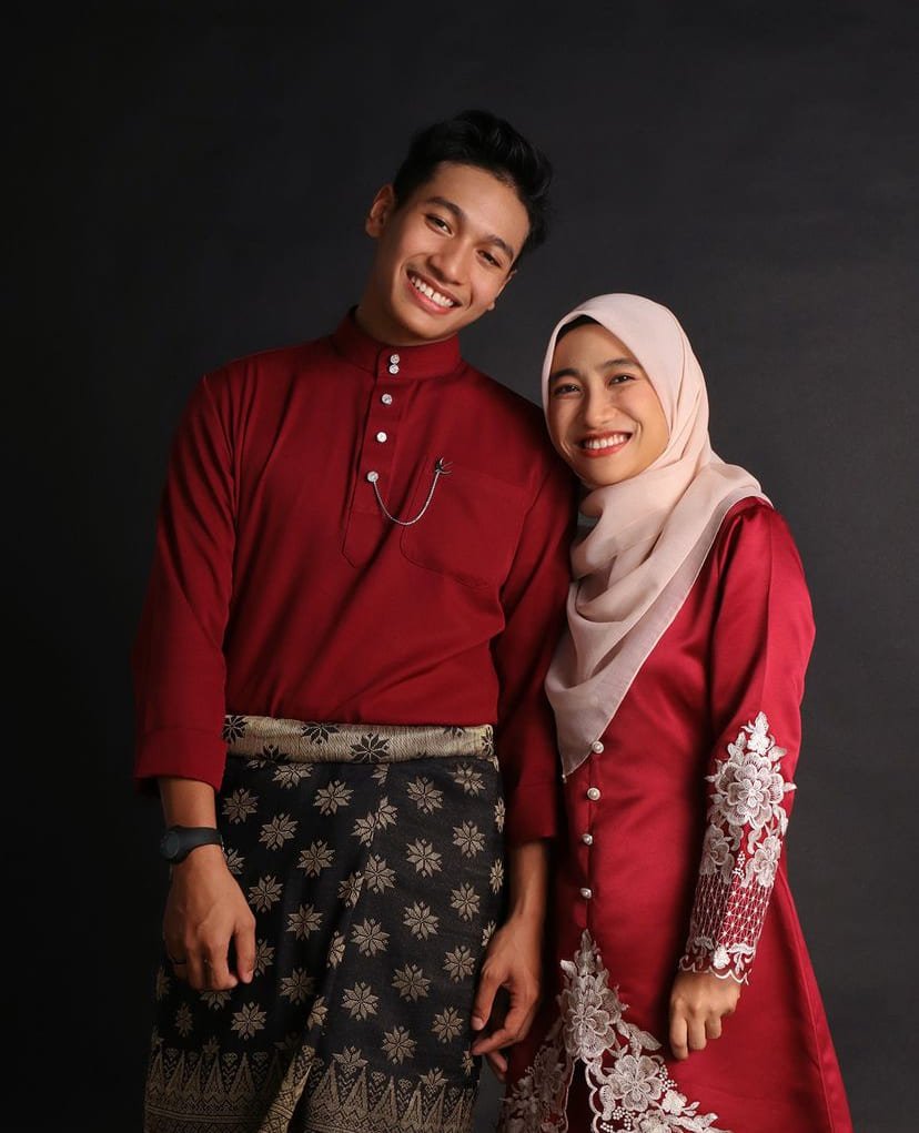 Malay couple wearing traditional clothes with black background in photo studio